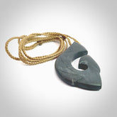 A hand carved large New Zealand Argillite Hook, Matau, necklace. The cord is a tan colour and is adjustable in length. A large sized hand made hook necklace by New Zealand artist Rueben Tipene. One off work of art to wear.